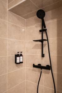 a shower with a black shower head in a bathroom at Le Mimi Mosa - Parking public gratuit, wifi haut débit, proche autoroute, gare & centre ville in Mâcon +11 photos
