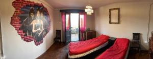 um quarto com uma cama com lençóis vermelhos e um mural em Vlads Place 
