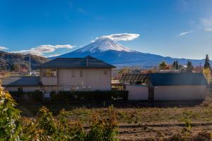 uma casa com uma montanha ao fundo em View of Mt Fuji Free transportation Bicycle Rental ok 富士山眺望 em Fujikawaguchiko