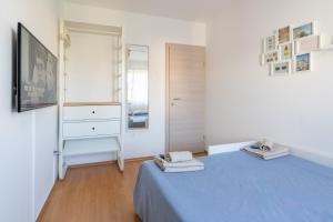 Sunny & Cosy Studio wParking في روفينج: غرفة نوم بيضاء مع سرير أزرق وخزانة