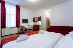 um quarto de hotel com duas camas e um sofá vermelho em Hotel Dagmar em Jáchymov