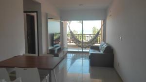 a living room with a dining table and a balcony at Residence Taormina no Cumbuco in Cumbuco