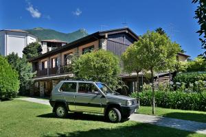 ein grünes Auto, das vor einem Haus parkt in der Unterkunft Al Segnavento Fasanella in Toscolano-Maderno
