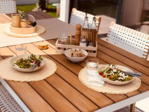 une table en bois avec des bols de nourriture dans l'établissement El Palmeral - Exlusive Villa with Private, Heated Pool in Corralejo, à Corralejo