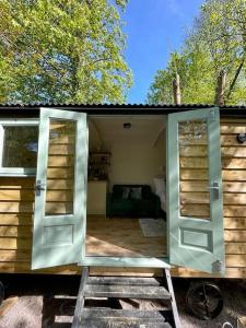 ein winziges Haus mit einer Tür und einer Leiter in der Unterkunft Cosy Shepherds Hut Lyme Regis in Uplyme