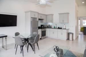 a kitchen and dining room with a glass table and chairs at 232A Upper Level, South Finger Jolly Harbour in Jolly Harbour