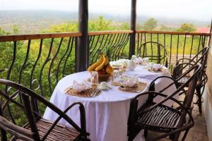 einen Tisch mit einem weißen Tischtuch und Bananen darauf in der Unterkunft Saba Holiday Homes in Machakos