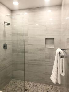 a bathroom with a glass shower stall with towels at 232A Upper Level, South Finger Jolly Harbour in Jolly Harbour