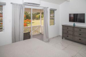 a bedroom with a bed and a sliding glass door at 101H Jolly Harbour, Garden View in Jolly Harbour