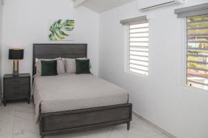 a white bedroom with a bed and a window at 101H Jolly Harbour, Garden View in Jolly Harbour