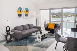 uma sala de estar com um sofá e uma mesa de vidro em 232G Upper Level, South Finger em Jolly Harbour