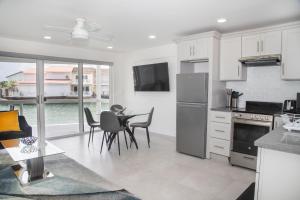 a kitchen with white cabinets and a table and chairs at 232G Lower Level, South Finger, Jolly Harbour in Bolans