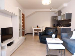 a living room with a couch and a tv at Denébola 112 by Sea You There Fuerteventura in Cotillo