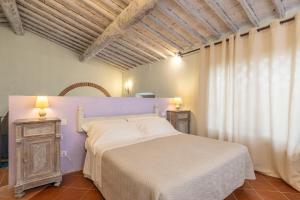 sypialnia z białym łóżkiem i oknem w obiekcie Borgo Casa al Vento w mieście Gaiole in Chianti
