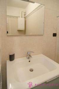 a bathroom with a white sink and a mirror at Goldoni 1 in Parma +10 photos