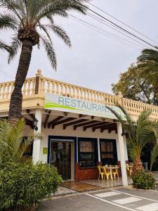 a restaurant with a palm tree in front of it at Las Palmeras in Crevillente