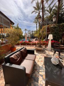 - un canapé installé sur une terrasse avec des palmiers dans l'établissement Las Palmeras, à Crevillente