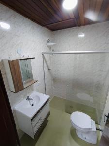 uma casa de banho com um WC branco e um lavatório. em Cantinho do sossego em Campos do Jordão