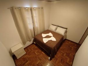 a small bedroom with a bed with two towels on it at Cantinho do sossego in Campos do Jordão