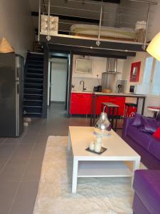 uma sala de estar com uma mesa e uma cozinha em CHARMANT STUDIO INDEPENDANT PROCHE MER parking privé em Mireval