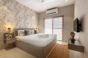 Un dormitorio con una gran cama blanca y una ventana en Blissful Grand 3BHK Villa Getaway Row Villa 2 en Camorlim