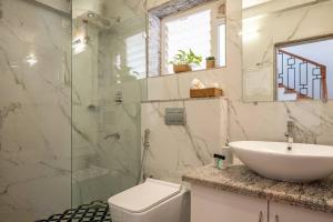 y baño con lavabo, aseo y ducha. en Blissful Grand 3BHK Villa Getaway Row Villa 2 en Camorlim