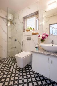 Baño blanco con lavabo y aseo en Blissful Grand 3BHK Villa Getaway Row Villa 2 en Camorlim
