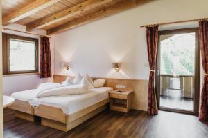 una camera con un letto bianco e una finestra di Thalguter - Rooms & Breakfast a Lagundo