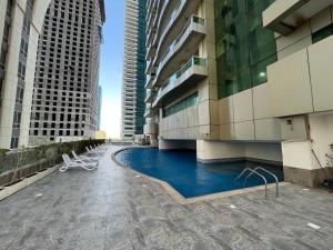 a swimming pool in the middle of a building with tall buildings at 1 bedroom Apartment with Dubai Marina & Seaview in Dubai