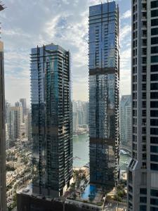 two tall buildings next to a river in a city at 1 bedroom Apartment with Dubai Marina & Seaview in Dubai