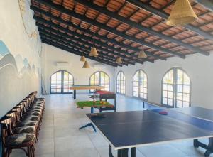 a large room with a ping pong table and chairs at Ponta Mar Resort in Ponta do Ouro
