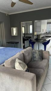 a living room with a couch and a kitchen at 389b Beautiful Bachelor Cottage in Johannesburg