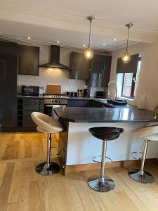 a kitchen with a large counter and bar stools at Luxury 2 Bedroom Aparmant in Morley in Morley