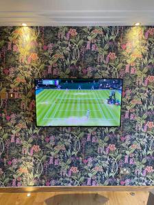a tv on a wall with a tennis game on it at Luxury 2 Bedroom Aparmant in Morley in Morley
