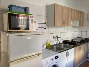 a kitchen with a microwave on top of a refrigerator at Leśniczówka Pokoje Gościnne in Gdynia