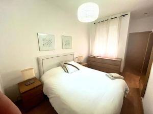 ein Schlafzimmer mit einem weißen Bett und einem Fenster in der Unterkunft Triana Marquesa in Melilla