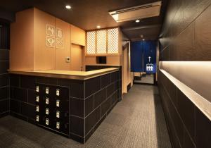 a bathroom with black tiled walls and a long hallway at Kyoto Sanjo Ohashi in Kyoto