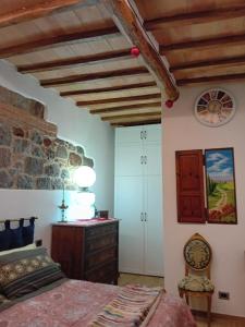 a bedroom with a bed and a stone wall at La Casa di Olga in Radicofani