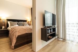 a bedroom with a bed and a flat screen tv at RentPlanet - Kras Resort in Szklarska Poręba