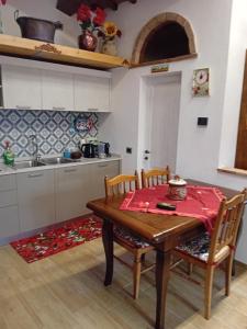 une cuisine avec une table et des chaises en bois ainsi qu'une cuisine avec un évier dans l'établissement La Casa di Olga, à Radicofani