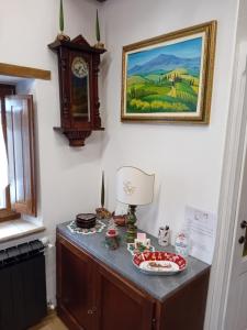 une table avec une horloge et une plaque de nourriture dans l'établissement La Casa di Olga, à Radicofani