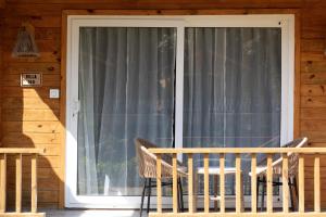 uma porta de vidro para um alpendre com cadeiras em Stone Wood Jungle Resort, Dandeli em Dandeli
