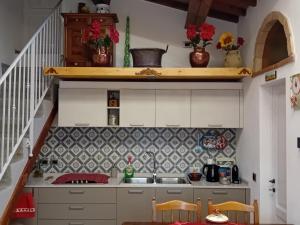 une petite cuisine avec un évier et un escalier dans l'établissement La Casa di Olga, à Radicofani