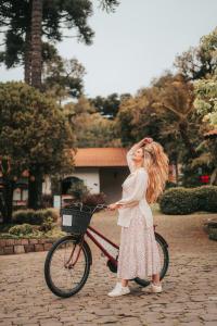 uma menina está ao lado de uma bicicleta em Vila Suzana Parque Hotel em Canela