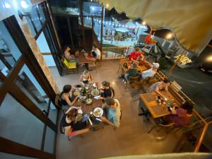 a group of people sitting at tables in a restaurant at Apartment Donend in Berat