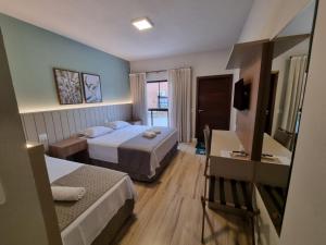 Cette chambre comprend deux lits et une télévision. dans l'établissement Pousada Salto Donner, à Rio Forcação