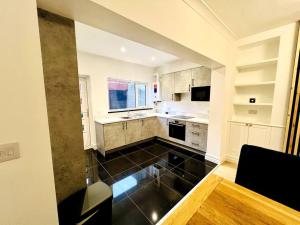 a kitchen with white cabinets and a black floor at Modern 2-bed in Blyth centre in Blythe
