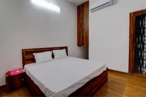 a bedroom with a white bed in a room at OYO Hotel Pitra Chaaya Hotel And Restaurant in Mathura
