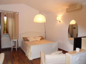 トレヴィニャーノ・ロマーノにあるHotel Il Casaleのベッドルーム(白いベッド1台、鏡付)