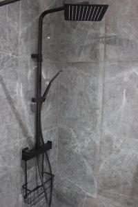 eine Dusche mit schwarzem Duschkopf im Bad in der Unterkunft Superbe Appartement avec Clim/Terrasse/Parking in Montpellier